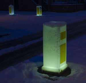 Close-up of snow on illuminated road during winter