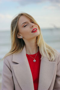 Portrait of a beautiful young woman with red lips on the sea