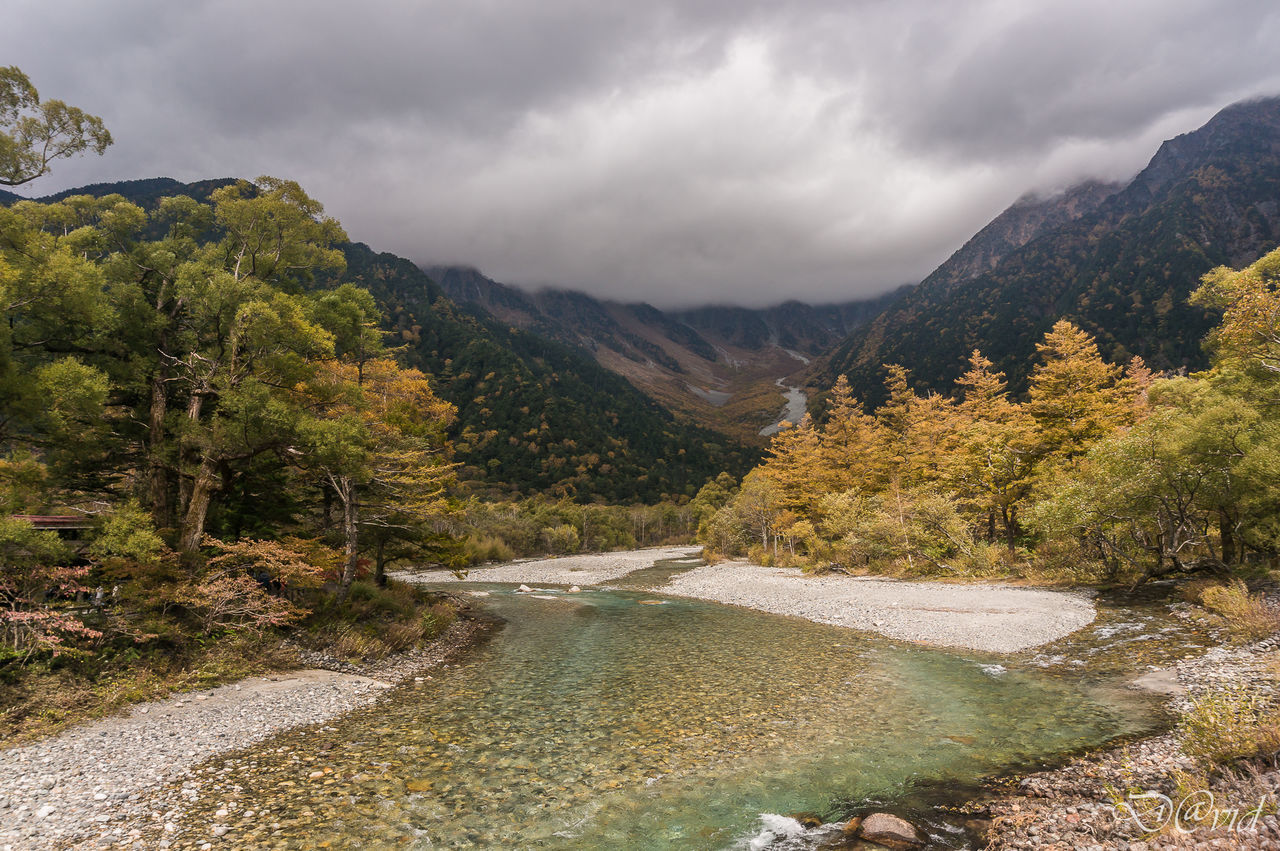 SCENIC VIEW OF RIVER AND MOUNTAINS AGAINST CLOUDY SKY