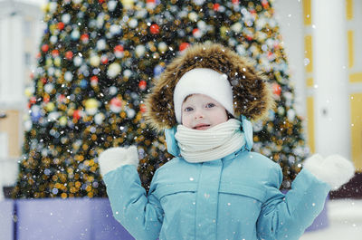 A cheerful girl on the background of a christmas tree.