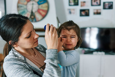 Brunette woman with child crying in her arms