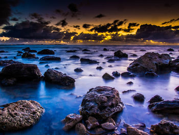 Rocks on shore at sunset