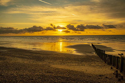 Scenic view of beach against sky during sunset