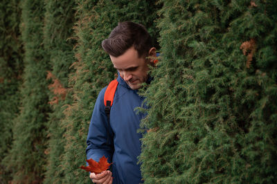 Side view of man standing in forest