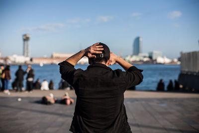 Man photographing against sky in city