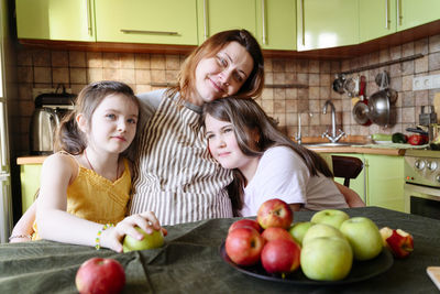Happy girl and fruits on table at home