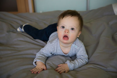 Portrait of cute girl lying on bed at home