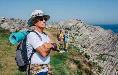 People standing on cliff against sky