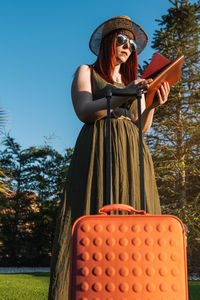 Rear view of woman wearing hat standing against trees