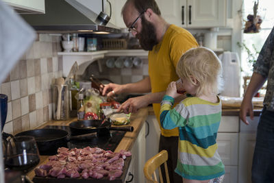 Father with daughter preparing food in kitchen