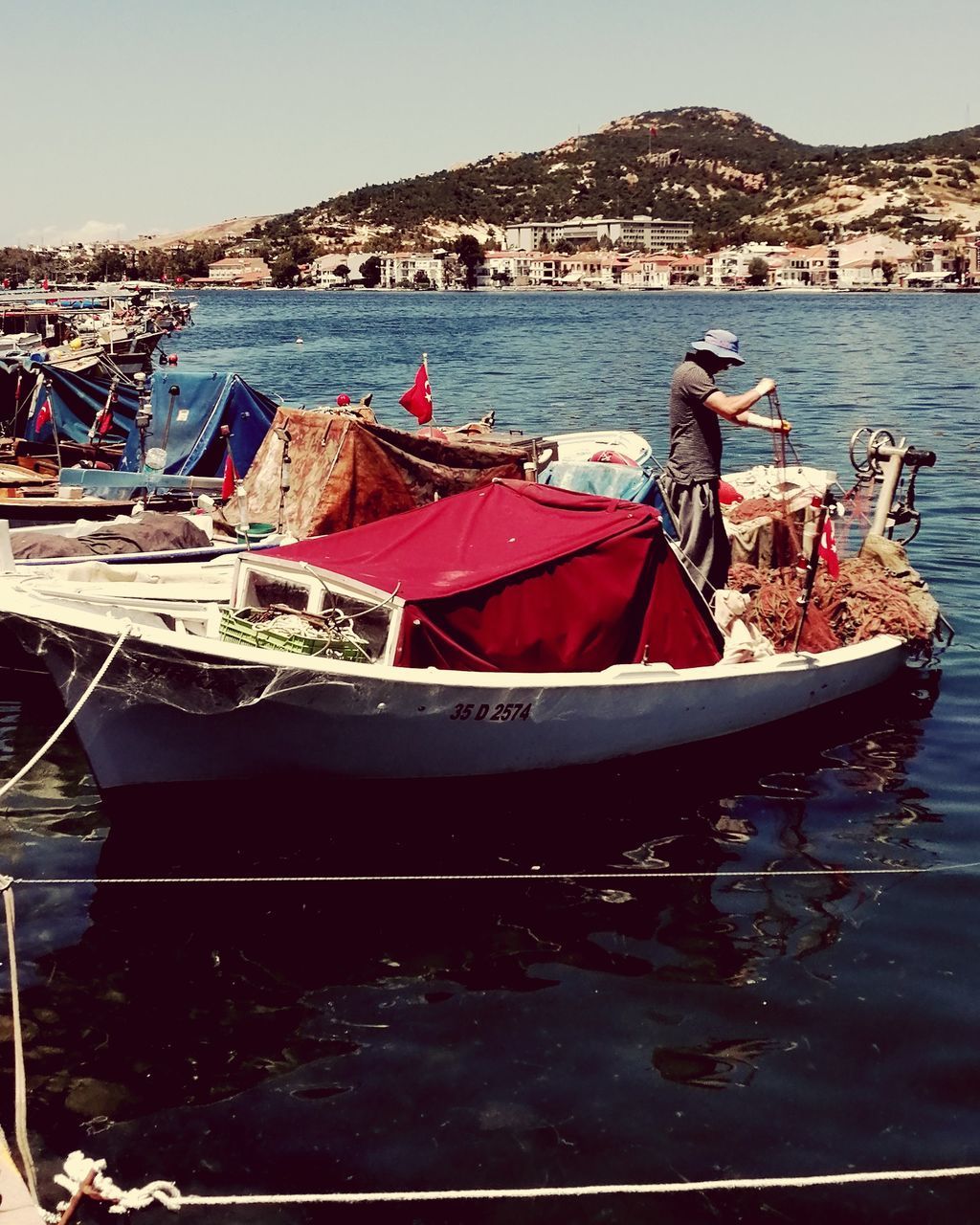 BOATS MOORED AT SEA AGAINST SKY