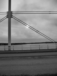 Electricity pylon against cloudy sky