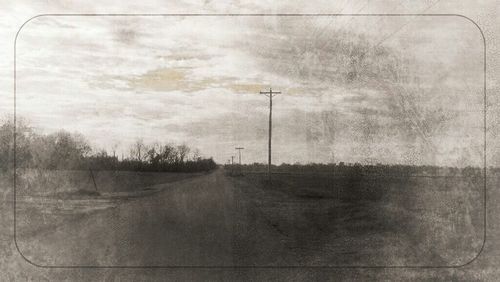 Power lines against cloudy sky