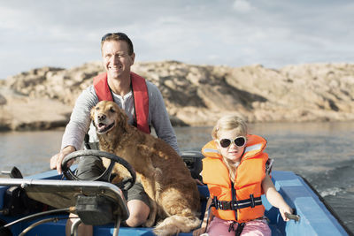 Man driving motorboat with daughter and dog in baltic sea