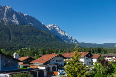 Town by mountains against clear blue sky