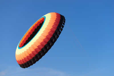 Low angle view of hot air balloons against clear blue sky