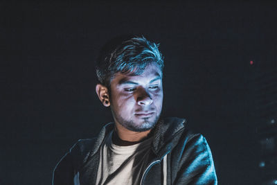 Thoughtful man against black background