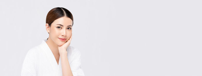 Portrait of beautiful young woman against white background