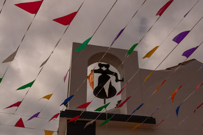 Low angle view of flags hanging against sky