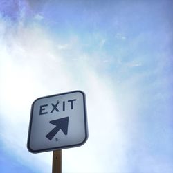 Low angle view of road sign against blue sky