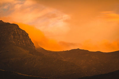 Scenic view of mountains against orange sky