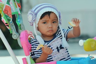 Portrait of cute girl sitting in baby stroller