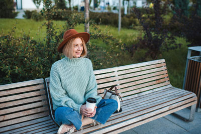 Young woman sitting on bench at park