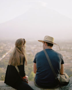 Rear view of people sitting against sky