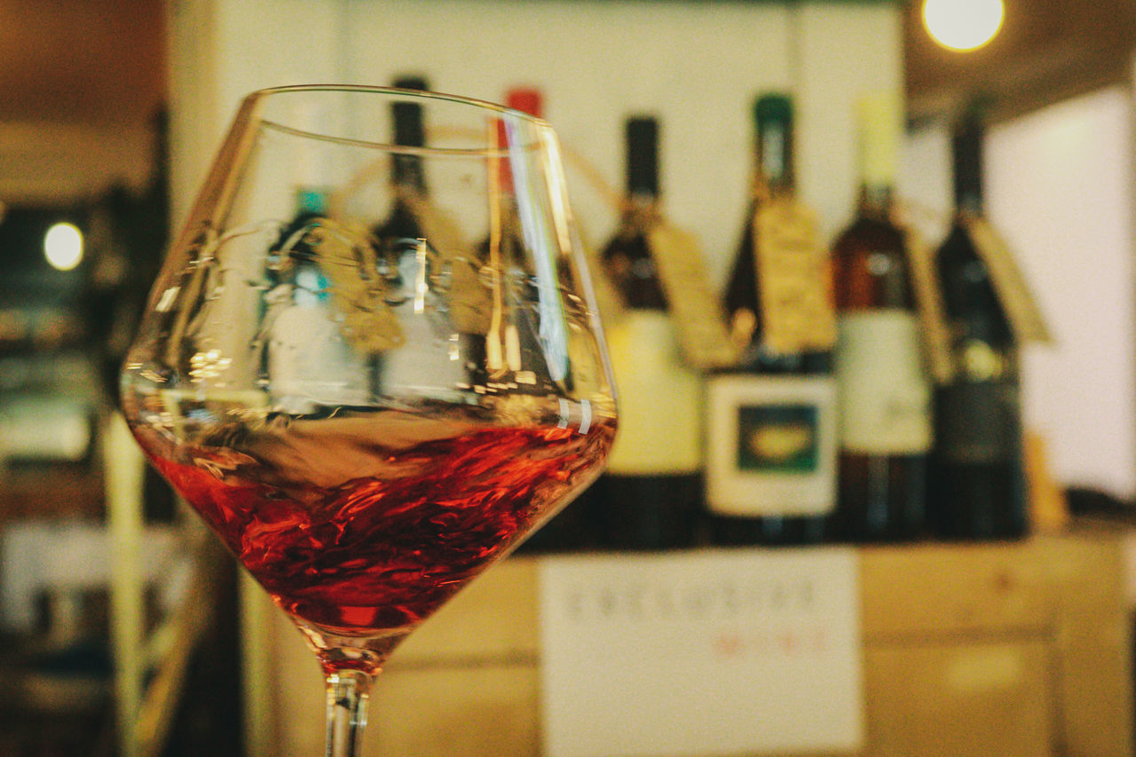 CLOSE-UP OF WINE GLASS ON TABLE