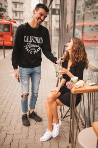 Full length of a smiling young woman having food