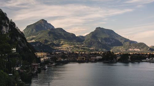 Scenic view of sea by townscape against sky