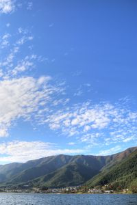 Scenic view of lake and mountains against blue sky