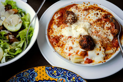 Lasagna and vegetable salad on the table.