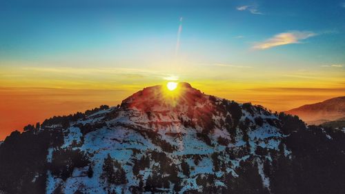 Scenic view of snowcapped mountains against sky during sunset