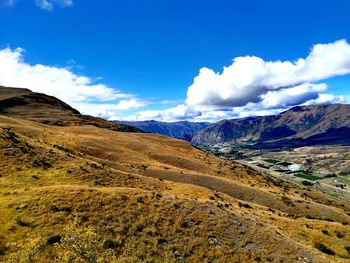 Panoramic view of landscape and mountains against blue sky