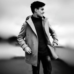 Smiling young man standing on road