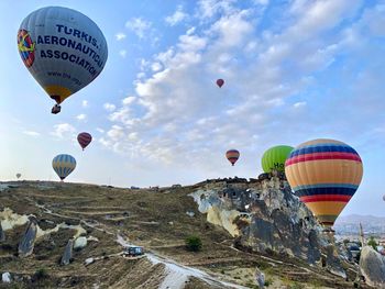 Hot air balloons flying over landscape against sky