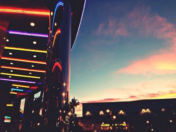 Low angle view of illuminated built structure against sky at night