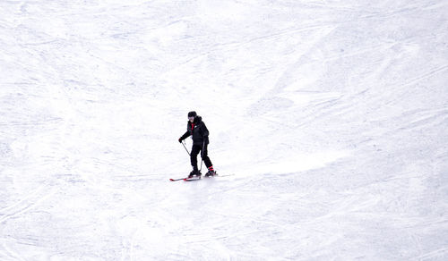 Full length of senior woman walking on snow covered mountain