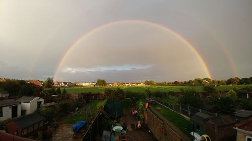 Scenic view of rainbow over trees against sky