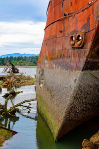 Abandoned boat on sea shore against sky
