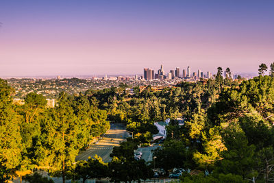 High angle view of trees and buildings against sky at sunset