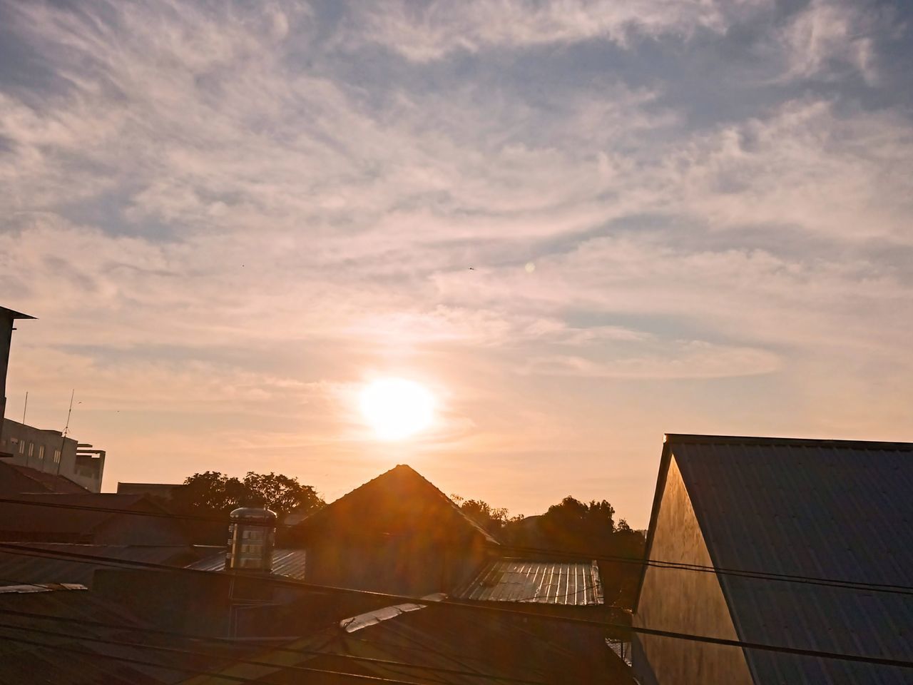 sunlight, sky, architecture, sunset, built structure, building exterior, cloud, sun, nature, building, evening, house, horizon, dusk, roof, city, no people, outdoors, environment, residential district, lens flare