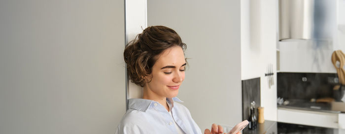 Side view of young woman standing at home