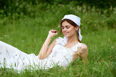 Portrait of young woman sitting on field