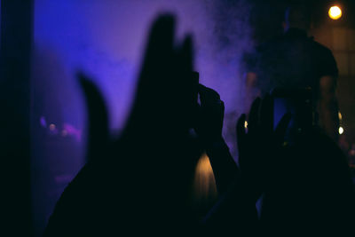 Close-up of silhouette people at music concert