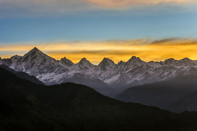 Scenic view of snowcapped mountains against sky during sunset