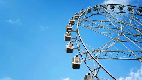 Low angle view of ferris wheel against blue sky