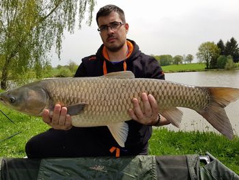 Full length of man holding fish in lake