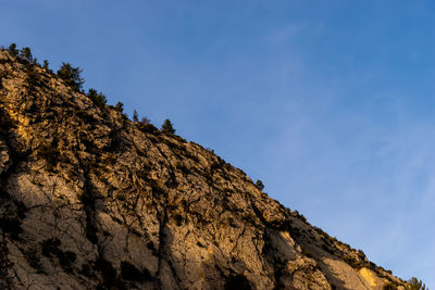 Low angle view of rock formation against clear blue sky